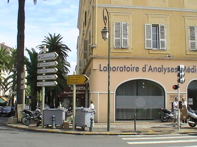 Ajaccio, 2008: угол улицы с вывеской 'Laboratoire d'Analyses Médicales' и указателем направлений к порту и аэропорту