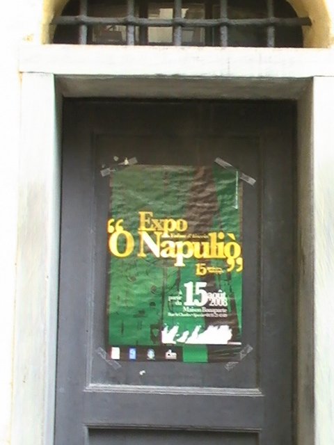 Ajaccio, 2008: постер выставки «Expo O Napulìò» на двери с решёткой