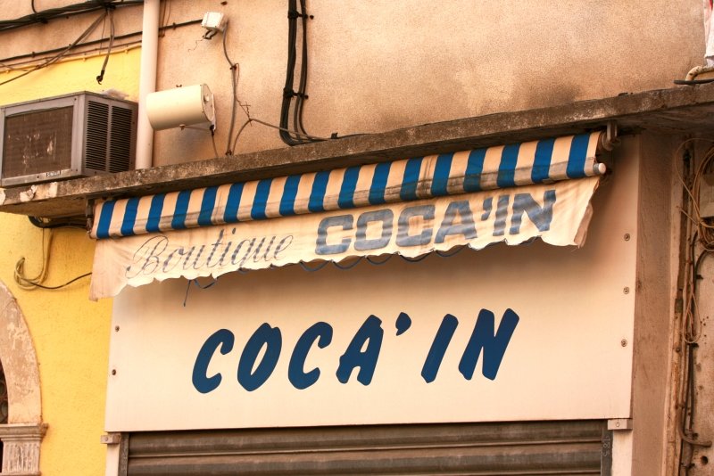 Бастия, Корсика, 2008: вывеска «Boutique COCA'IN» под полосатым навесом