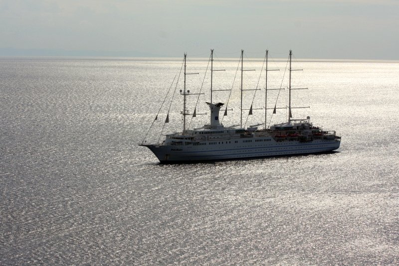 Белый круизный лайнер с четырьмя мачтами на спокойном море