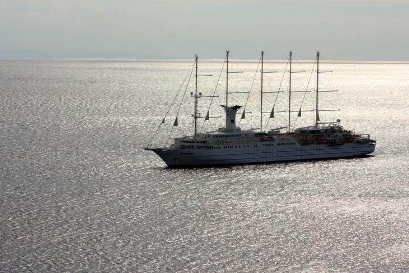 Белый круизный лайнер с четырьмя мачтами на спокойном море