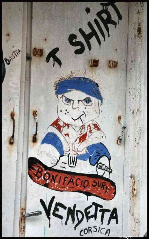 Корсика, 2009: дверь с рисунком мальчика и надписями «T SHIRT», «BONIFACIO SURF», «VENDetta CORSICA»