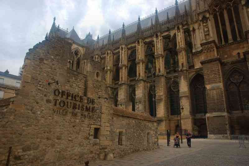 Reims: готический собор и старинная стена с вывеской 'Office de Tourisme'
