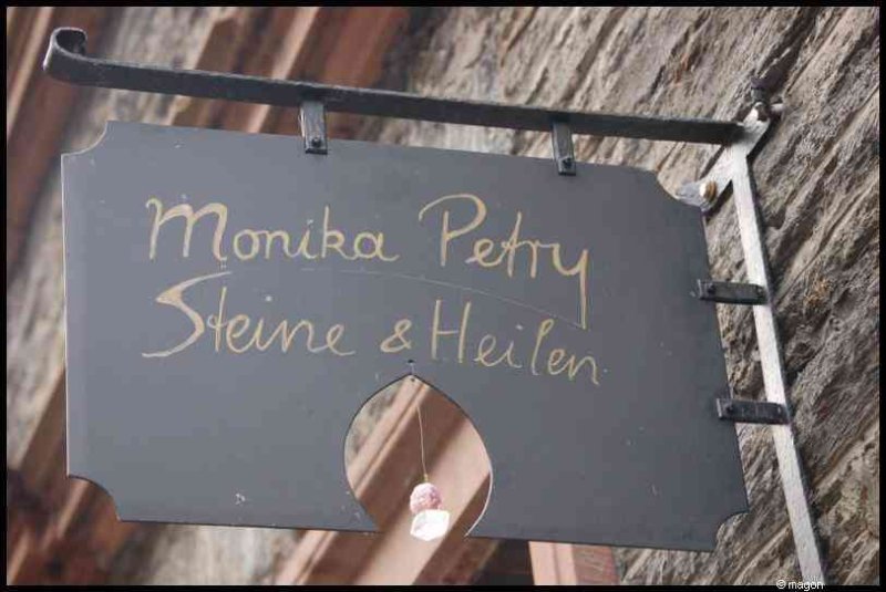 Трабен-Трарбах, Германия: вывеска «Monika Petry Steine & Heilen» у старинной стены