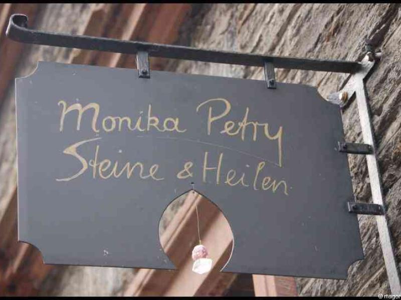 Трабен-Трарбах, Германия: вывеска «Monika Petry Steine & Heilen» у старинной стены