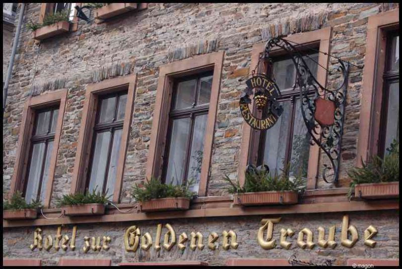 Отель zur Goldenen Traube в Трабен-Трарбахе: каменная фасадная стена с коваными вывесками