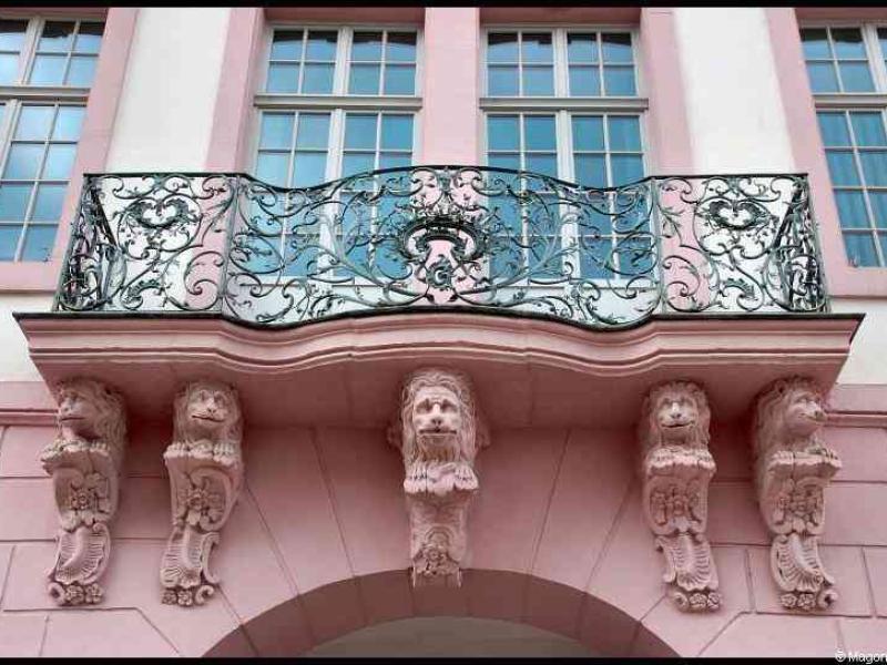 Львиные капители над аркой в Трире: розовая фасадная деталь барокко