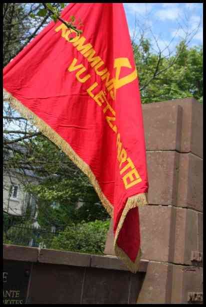 Красный флаг с надписью «KOMMUNISTE VU LETZT MÄRTEI» у памятника в Люксембурге, 2009