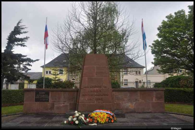 Мемориал в Люксембурге, 7 мая 2012: бетонный памятник с цветами и флагами