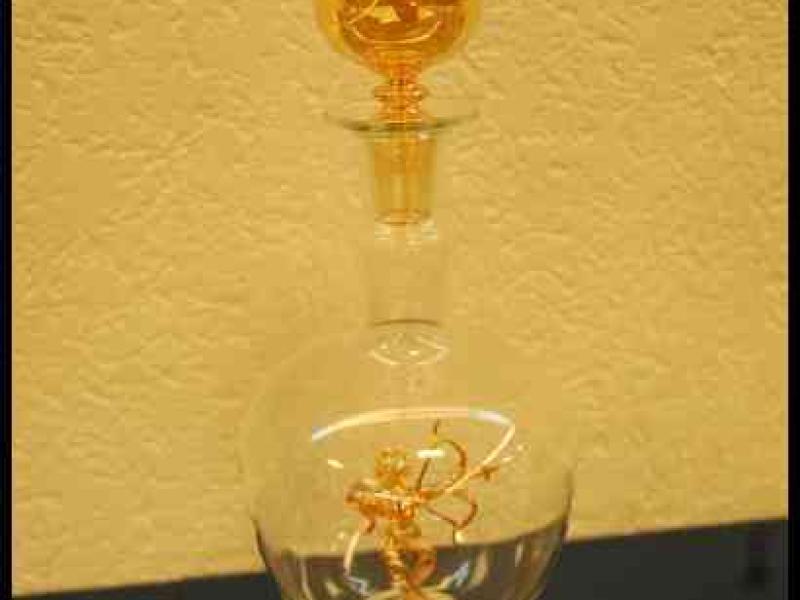 Art Du Cristal, Люксембург: золотистая бутылка с фигуркой в стеклянном шаре