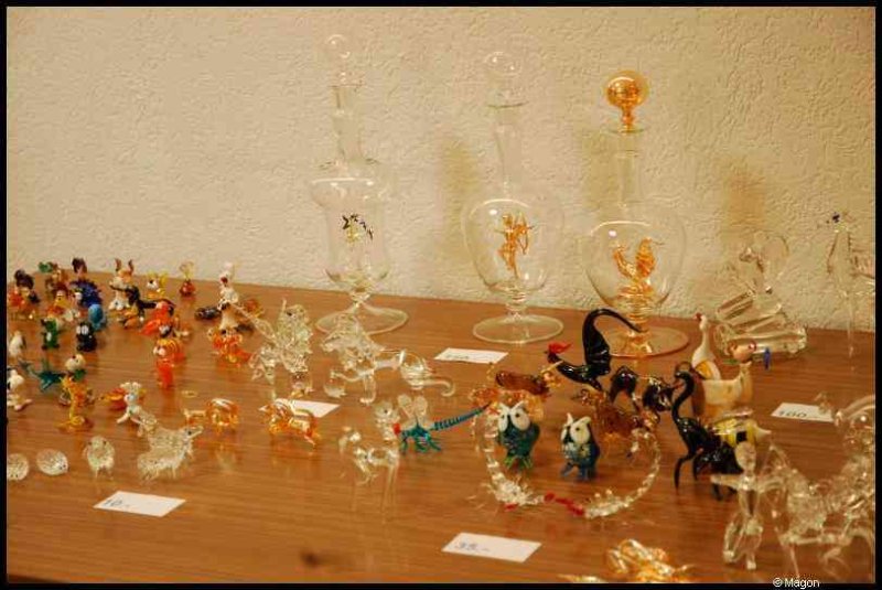 Art Du Cristal в Люксембурге: стеклянные фигурки и бутылки на деревянном столе