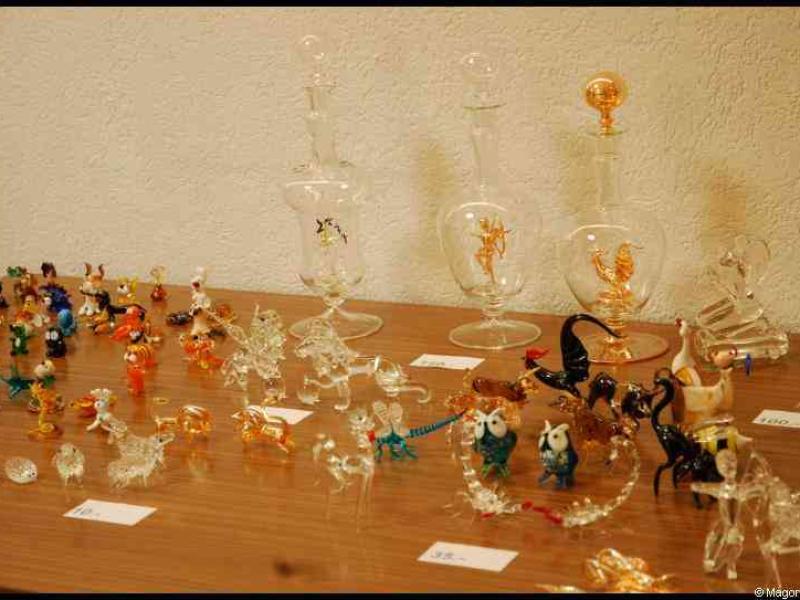 Art Du Cristal в Люксембурге: стеклянные фигурки и бутылки на деревянном столе