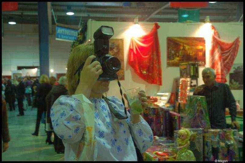 Женщина с фотоаппаратом и вспышкой на выставке