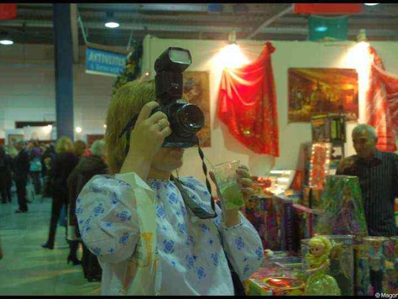 Женщина с фотоаппаратом и вспышкой на выставке