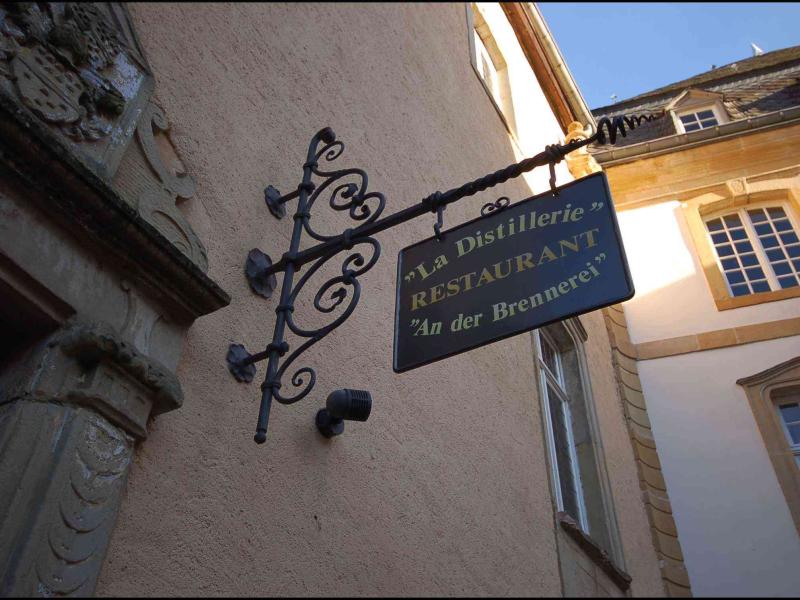 Bourglinster, Люксембург: вывеска «La Distillerie» над входом в старинное здание