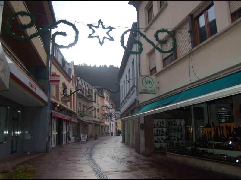 Улица в Clervaux, Люксембург: зелёные гирлянды над каменной мостовой