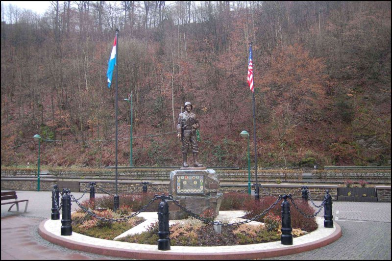 Памятник солдату в Clervaux, Люксембург: флаги Нидерландов и США у подножия холма
