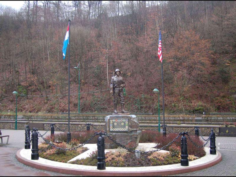 Памятник солдату в Clervaux, Люксембург: флаги Нидерландов и США у подножия холма
