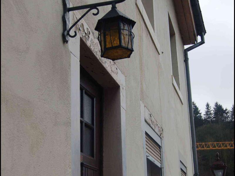 Фасад здания в Люксембурге с настенным фонарём и почтовым ящиком