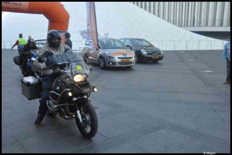 Eurobikers 2012 в Люксембурге: мотоциклист с багажниками у арки и современного здания