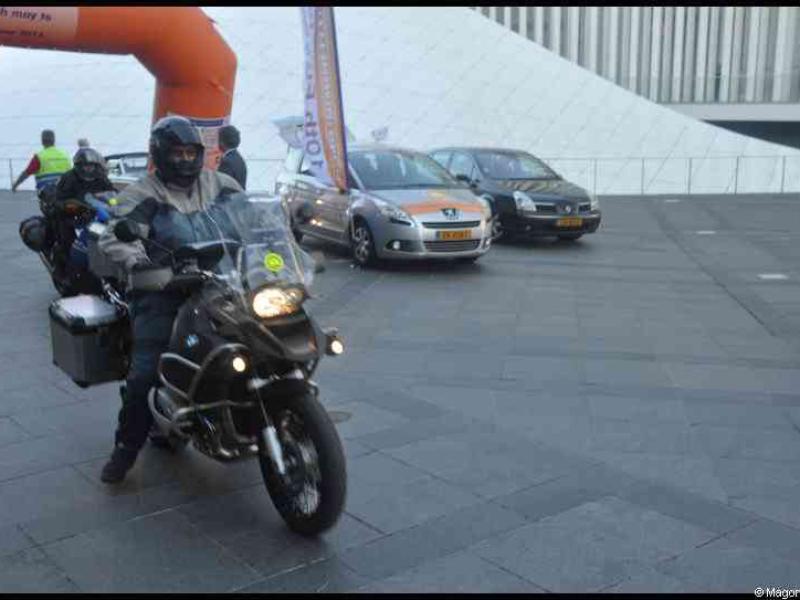 Eurobikers 2012 в Люксембурге: мотоциклист с багажниками у арки и современного здания