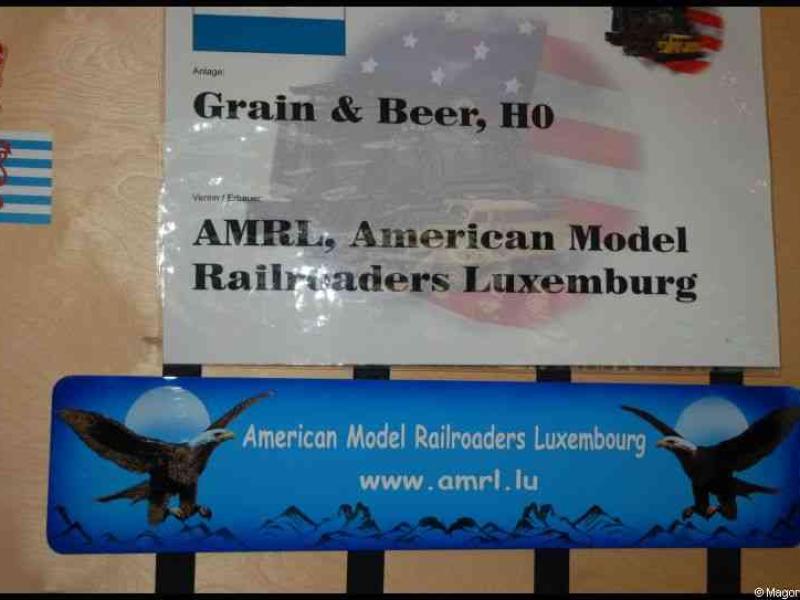 Expo train 2010 в Люксембурге: вывеска AMRL и флаги у стенда