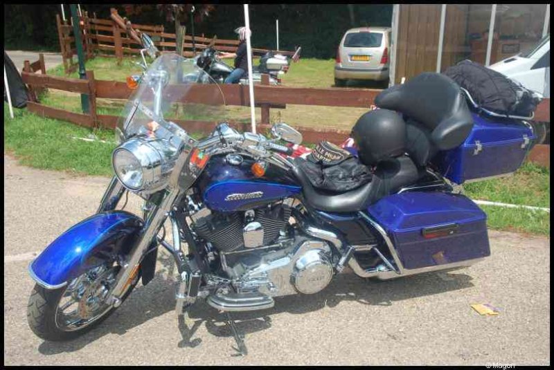 Hog, Люксембург, 2010: синий Harley-Davidson с багажниками у деревянного забора