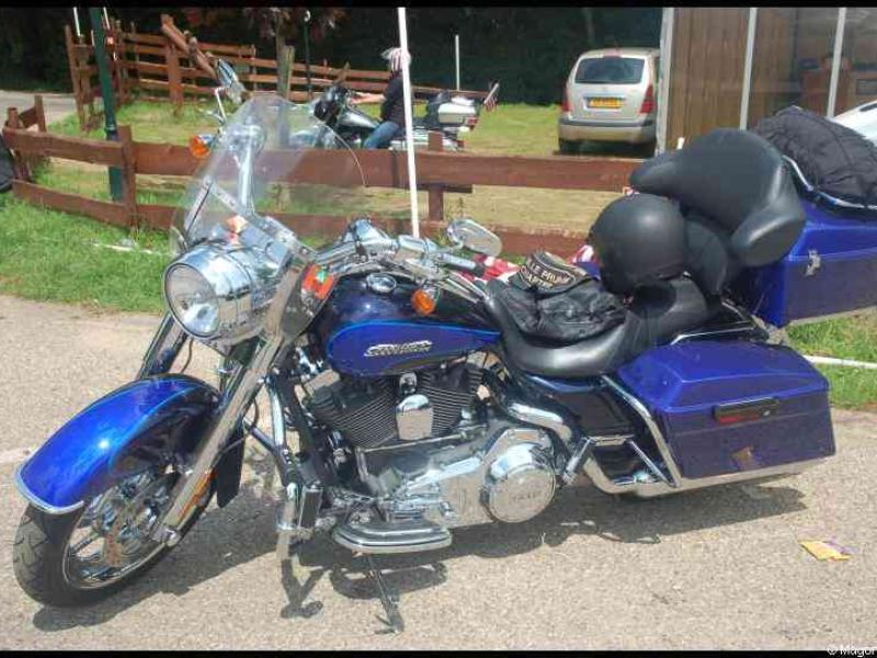 Hog, Люксембург, 2010: синий Harley-Davidson с багажниками у деревянного забора