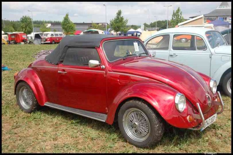 Красный кабриолет Volkswagen Beetle с черным верхом на выставке классических автомобилей