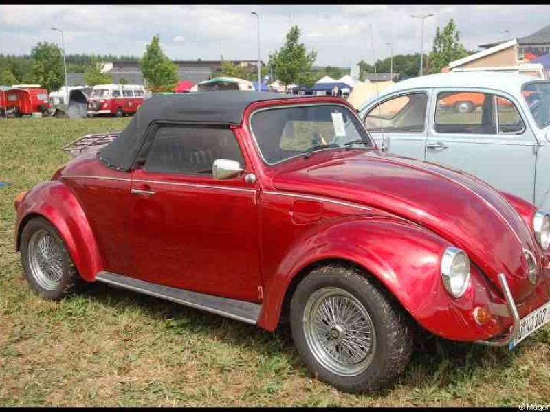 Красный кабриолет Volkswagen Beetle с черным верхом на выставке классических автомобилей