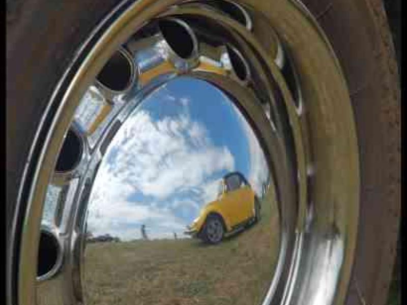 Luxbug 2010: отражение жёлтого кабриолета в хромированном колесе