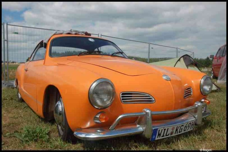 Luxbug 2010: оранжевый VW Karmann Ghia на лужайке у забора