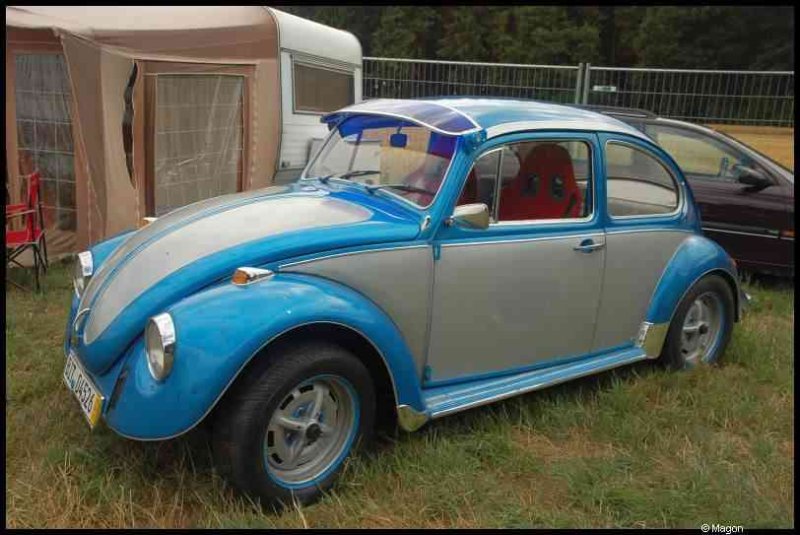 Luxbug 2010: сине-серый Волксваген-Жук с красным креслом на траве Люксембурга