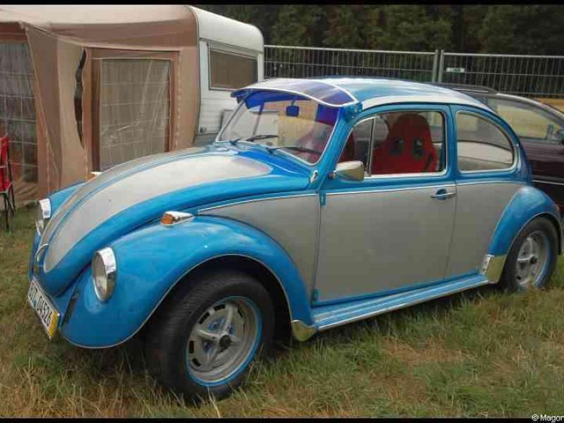 Luxbug 2010: сине-серый Волксваген-Жук с красным креслом на траве Люксембурга