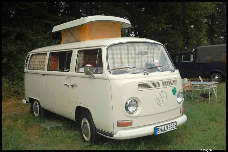 Белый Volkswagen Type 2 с поднятым верхом и желтым куполом на крыше