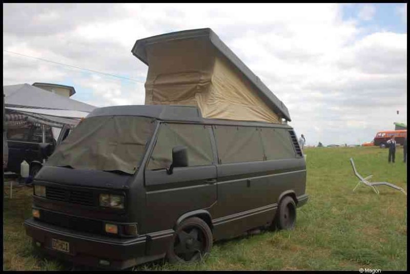 Luxbug 2010: чёрный фургон с кемпинг-капотом на лужайке в Люксембурге