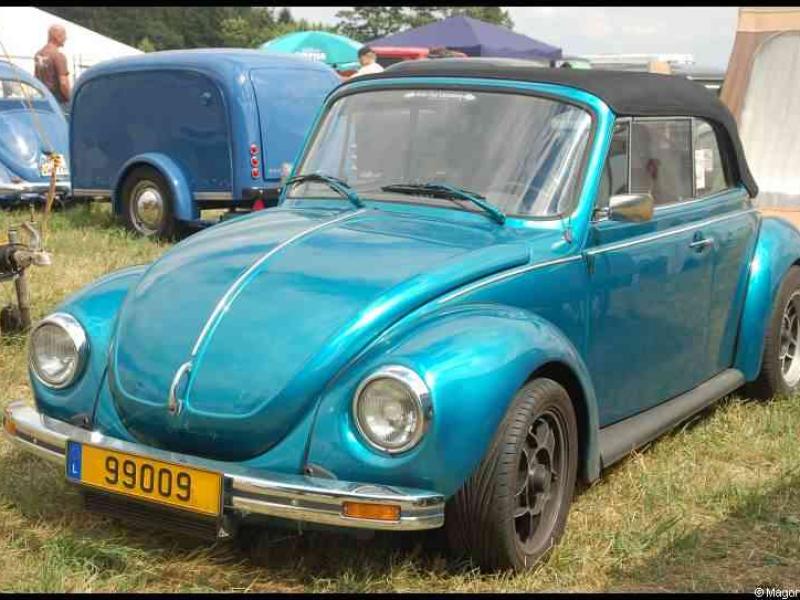 Luxbug 2010: бирюзовый VW Beetle с черным верхом на лужайке в Люксембурге