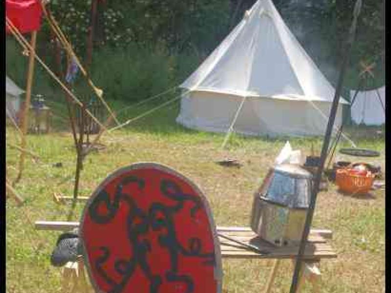 Medieval Festival Useldange, Люксембург: красный щит с змеевидным узором у деревянного стола