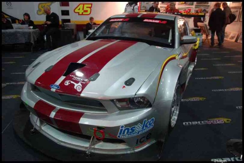 Белый гоночный Ford Mustang с красными полосами на выставке