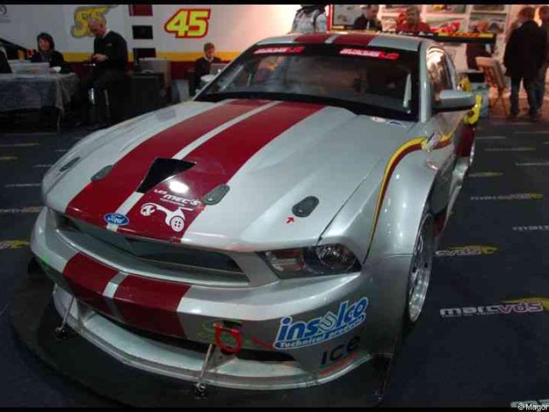 Белый гоночный Ford Mustang с красными полосами на выставке