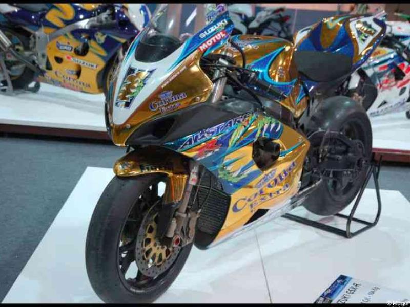 Спортивный мотоцикл Suzuki с золотисто-синей ливреей на выставке