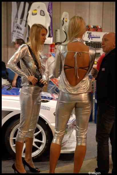 Motorshow 2010 в Люксембурге: две женщины в серебристых костюмах у белого гоночного автомобиля