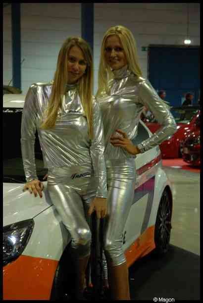Motorshow 2010 в Люксембурге: две женщины в серебристых костюмах у бело-оранжевого автомобиля