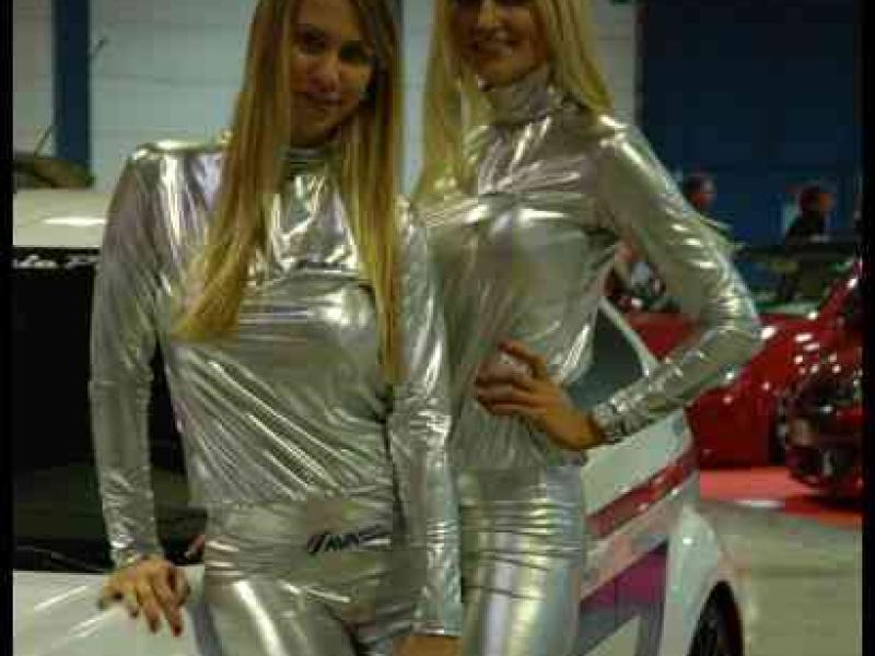 Motorshow 2010 в Люксембурге: две женщины в серебристых костюмах у бело-оранжевого автомобиля