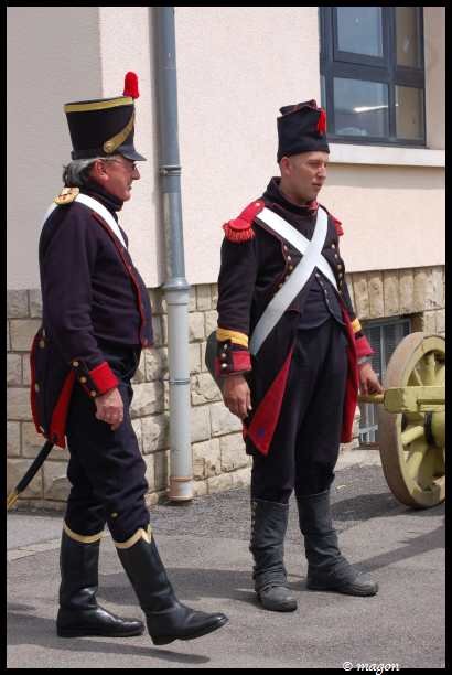 Napoleonic Bivouac в Люксембурге: два солдата в мундирах 1812 года у пушечного колеса