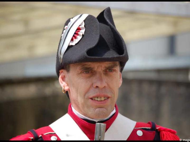 Napoleonic Bivouac в Люксембурге: солдат в красно-чёрном мундире с фуражкой и лентой