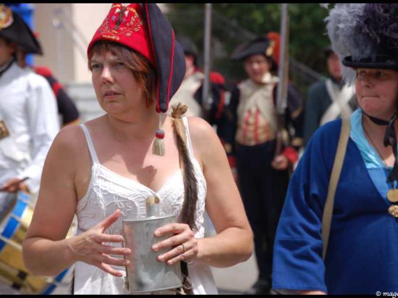 Napoleonic Bivouac в Люксембурге: женщина в красно-чёрной фуражке с кисточкой и металлическим флягом