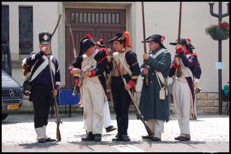 Napoleonic Bivouac в Люксембурге: солдаты в мушкетах и фуражках у деревянных ворот
