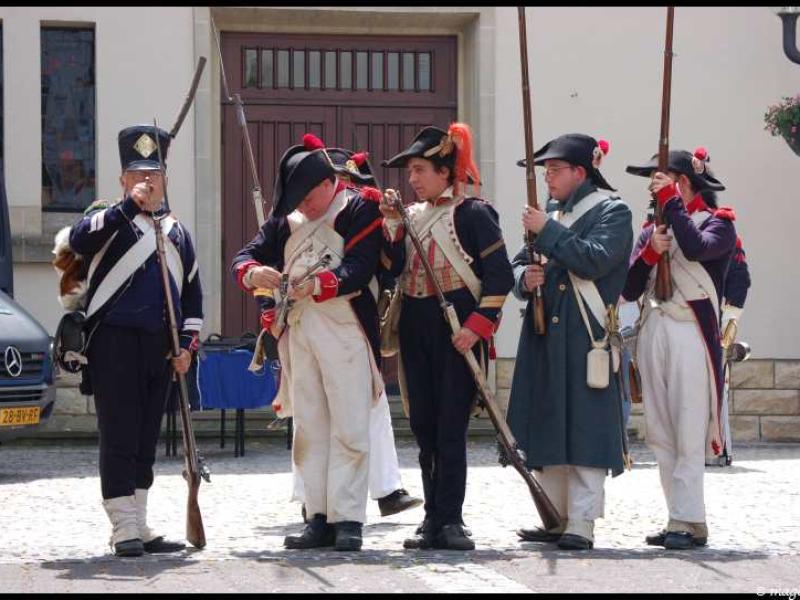 Napoleonic Bivouac в Люксембурге: солдаты в мушкетах и фуражках у деревянных ворот