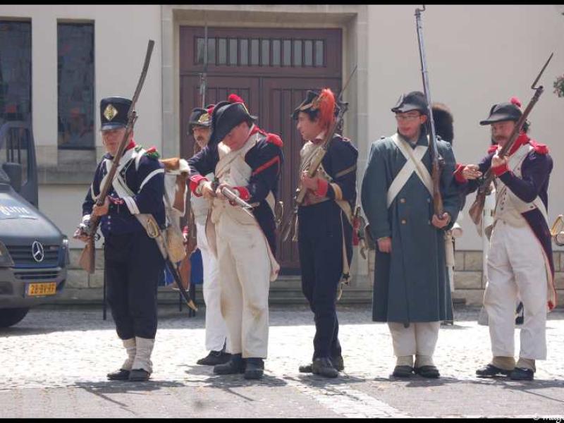 Napoleonic Bivouac в Люксембурге: солдаты в мундирах 1810-х годов у деревянных дверей здания